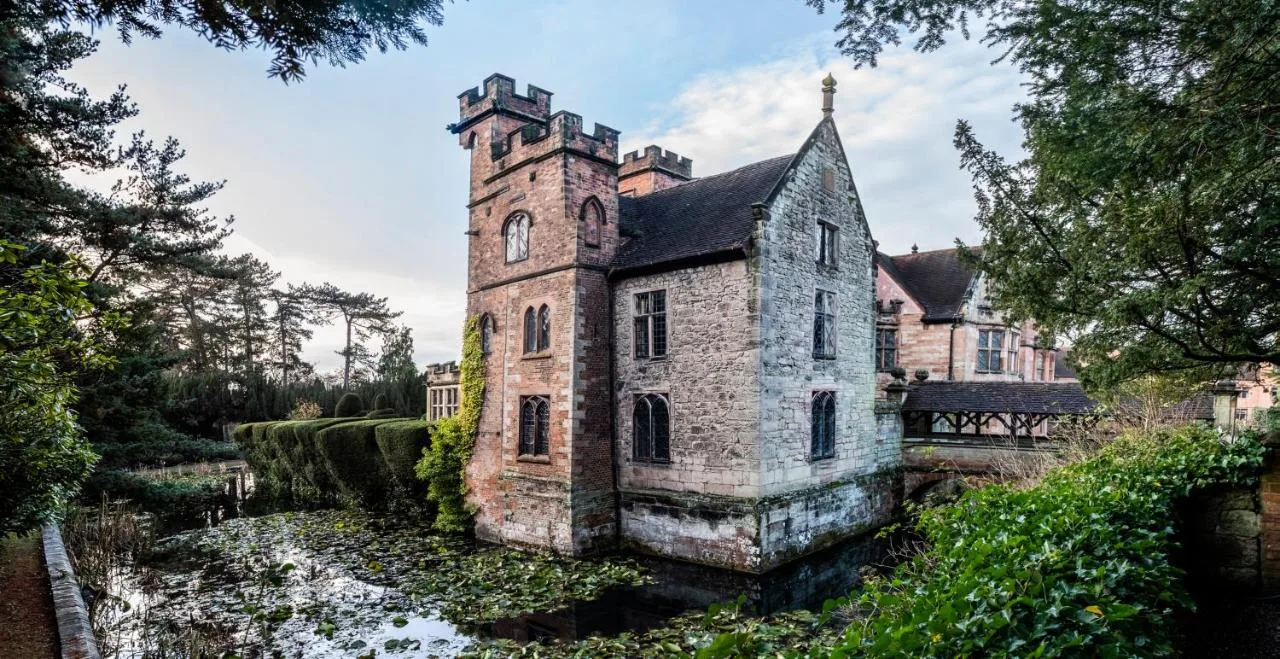 an old stone building in the middle of a river at New Hall Hotel & Spa, Birmingham in Birmingham