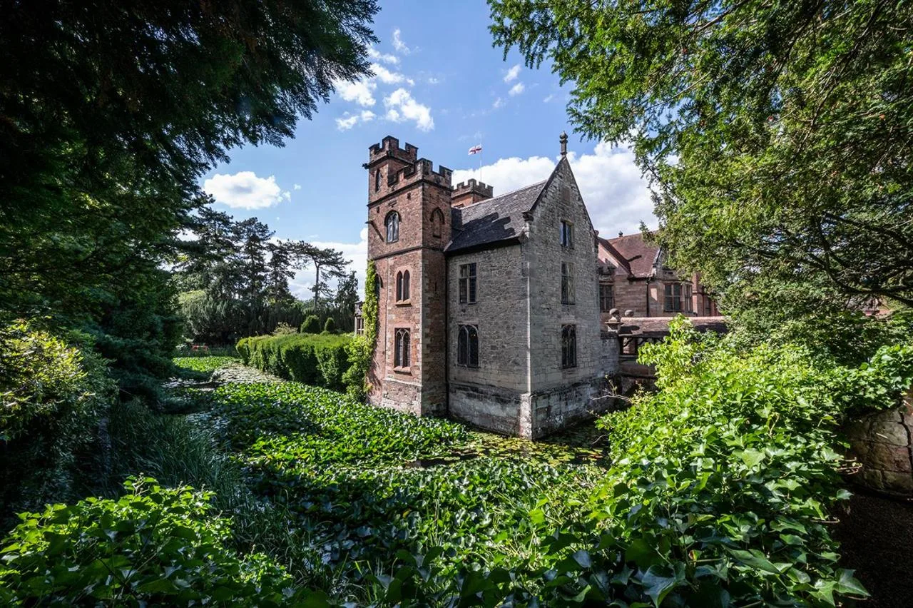 an old building with a clock tower in a field at New Hall Hotel & Spa, Birmingham in Birmingham