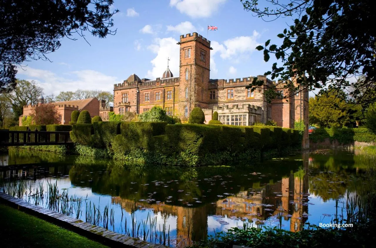 a castle with a pond in front of it at New Hall Hotel & Spa, Birmingham in Birmingham