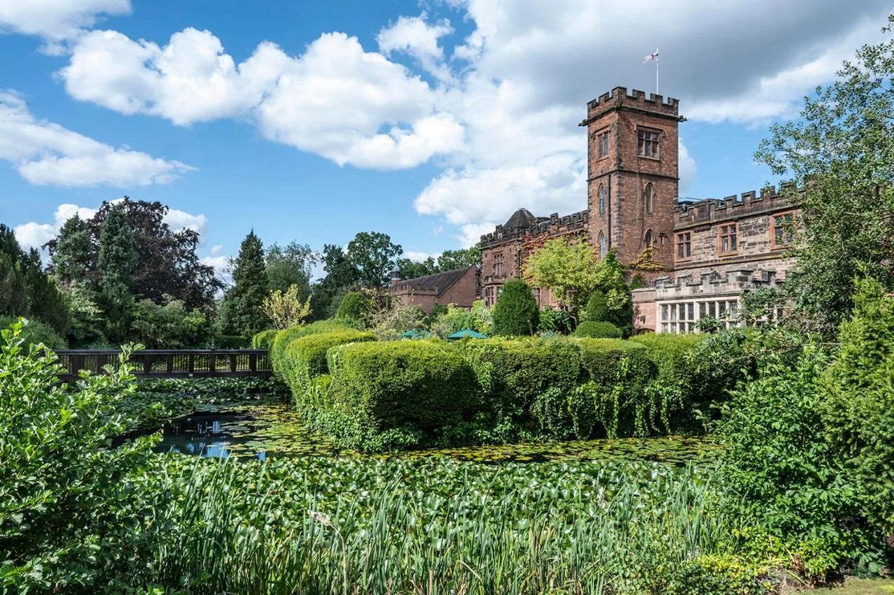 a building with a clock tower next to a river at New Hall Hotel & Spa, Birmingham in Birmingham